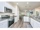 Bright kitchen with white cabinets, stainless steel appliances, and an open layout to the living area at 141 Clydesdale Cir, Summerville, SC 29486
