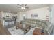 Open-concept living room with view to kitchen, featuring a leather sofa, ceiling fan, and stylish rug at 141 Clydesdale Cir, Summerville, SC 29486