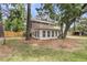 Back exterior of home, featuring an enclosed patio area, wooden fence, and mature trees at 1541 Hutton Pl, Charleston, SC 29407
