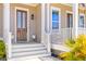 Inviting front porch with wooden door, lantern, and bright landscaping at 1580 Cranes Nest Rd, Mount Pleasant, SC 29466