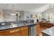 Open kitchen featuring wood cabinetry, stainless steel dishwasher, and a view into the living room at 1606 Whitby Ln, Charleston, SC 29414