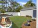Landscaped backyard with lawn, fence, shed, patio, surfboard rack and raised flowerbeds under a blue sky at 1753 Bee Balm Rd, Johns Island, SC 29455