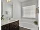 Bright bathroom with a soaking tub, white vanity, and natural light from the window at 1753 Bee Balm Rd, Johns Island, SC 29455