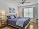 Cozy bedroom with a blue bed, hardwood floors, ceiling fan, and bright natural light at 1753 Bee Balm Rd, Johns Island, SC 29455