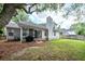 A well-maintained backyard with a screened-in porch, a brick patio, and a chimney in a residential home at 1922 Cedar Petal Ln, Charleston, SC 29414