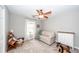 Bright bedroom with a ceiling fan boasts neutral tones, perfect for relaxation or use as a playroom at 1922 Cedar Petal Ln, Charleston, SC 29414