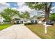 Traditional one-story home with gray siding, dark shutters, lush lawn, and a long driveway leading to the garage at 1922 Cedar Petal Ln, Charleston, SC 29414