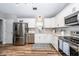 Modern kitchen with stainless steel appliances, white cabinetry, light countertops, and hardwood flooring at 1922 Cedar Petal Ln, Charleston, SC 29414