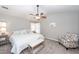 Comfortable bedroom boasts neutral tones, ceiling fan, and an upholstered chair, perfect for relaxing at 1922 Cedar Petal Ln, Charleston, SC 29414