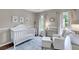 Cozy Bedroom featuring a white crib, chair, and ottoman, with a blue patterned rug and natural light at 1938 Oak Tree Ln, Mount Pleasant, SC 29464