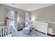 Calming Bedroom features a white crib, a plush chair, and natural light with pale blue accents at 1938 Oak Tree Ln, Mount Pleasant, SC 29464