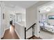 Upstairs hallway with wood floors leads to bedrooms, with black iron railings and white trim at 1938 Oak Tree Ln, Mount Pleasant, SC 29464