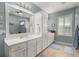 Bright and spacious bathroom featuring double sinks, storage cabinets, and a window with plantation shutters at 1992 Kings Gate Ln, Mount Pleasant, SC 29466