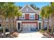 Charming two-story townhome featuring a garage, front yard landscaping, and a driveway with blue chairs at 1992 Kings Gate Ln, Mount Pleasant, SC 29466
