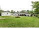 Large backyard with green grass, a covered patio, detached garage, and a fire pit at 203 Red Fox Run, Summerville, SC 29485