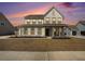 Beautifully lit two-story home with a welcoming front porch and well-maintained landscaping at sunset at 2064 Parish House Cir, Johns Island, SC 29455