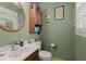 This charming bathroom features olive walls, wood cabinets, and decorative details at 2138 Clayton St, Charleston, SC 29414