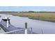 A private boat dock on a calm waterway leads to a picturesque marsh landscape with bridge in the background at 2206 Weepoolow Trl, Charleston, SC 29407