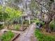 Beautiful garden with raised beds, stone path, and sitting bench under Spanish moss-draped trees at 2206 Weepoolow Trl, Charleston, SC 29407