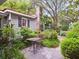 Cozy brick patio with a table and chair set, surrounded by lush gardens and a charming white fence at 2206 Weepoolow Trl, Charleston, SC 29407