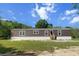 Single-story home featuring a brown exterior, trimmed with white, and well-maintained lawn under a blue sky at 226 Collier Ln, Moncks Corner, SC 29461