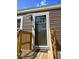 Close-up of the front door featuring brown siding, a welcome mat, and wooden stairs leading to the entrance at 226 Collier Ln, Moncks Corner, SC 29461