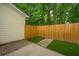 Cozy backyard with a wooden fence, a small strip of green grass, and a paved area at 241 Howle Ave # H, Charleston, SC 29412