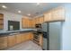 Modern kitchen with stainless steel appliances, light wood cabinets, and gray countertops at 241 Howle Ave # H, Charleston, SC 29412