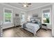 Bright bedroom with hardwood floors, a queen bed, dresser, side tables, and windows at 2729 Battery Pringle Dr, Johns Island, SC 29455