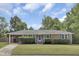 Charming brick ranch with blue shutters, mature landscaping and a covered parking area at 296 Oxford Rd, Ladson, SC 29456