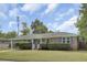 Well-maintained brick home with lush lawn, classic shutters and covered parking on a sunny day at 296 Oxford Rd, Ladson, SC 29456