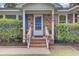 Close up of brick porch with charming entrance, white door, and potted plants at 296 Oxford Rd, Ladson, SC 29456