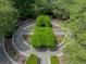 An aerial view showcases a lush, beautifully landscaped garden, featuring geometric hedge designs and circular pathways at 2970 Roseville Rd, Wadmalaw Island, SC 29487