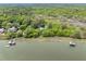 Expansive aerial view of a waterfront home nestled amidst lush trees, featuring private dock and pier at 2970 Roseville Rd, Wadmalaw Island, SC 29487