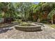 Picturesque backyard featuring a circular stone patio, fountain, and lush landscaping at 2970 Roseville Rd, Wadmalaw Island, SC 29487