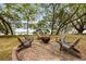 Circular brick fire pit area with chairs and views of the water at 2970 Roseville Rd, Wadmalaw Island, SC 29487