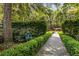 Whimsical garden path with charming frog statue, lush greenery, and manicured hedges creating a serene outdoor space at 2970 Roseville Rd, Wadmalaw Island, SC 29487