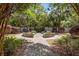 Lush backyard garden featuring manicured hedges, palm trees, and stone walkways at 2970 Roseville Rd, Wadmalaw Island, SC 29487