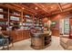 An elegant home office with wood paneled walls, coffered ceilings, built-in bookshelves, and traditional furniture at 2970 Roseville Rd, Wadmalaw Island, SC 29487
