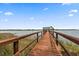 Scenic pier with a covered seating area extends into the water, offering picturesque views of the bay at 2970 Roseville Rd, Wadmalaw Island, SC 29487