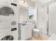Modern bathroom with a sleek shower, vanity, and stacked washer and dryer for convenience at 308 Watergrass St, Summerville, SC 29486