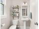Cozy powder room features a pedestal sink and decorative shelving and modern fixtures at 308 Watergrass St, Summerville, SC 29486