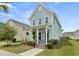 Charming two-story home with a covered front porch featuring rocking chairs and lush landscaping at 308 Watergrass St, Summerville, SC 29486