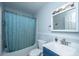 Clean bathroom with a blue shower curtain, blue vanity and well-lit vanity mirror at 312 Lake Moultrie Dr, Bonneau, SC 29431