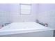 Well-lit bathroom features a large bathtub with tile surround and a window at 312 Lake Moultrie Dr, Bonneau, SC 29431