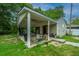 Backyard with a covered patio, an open garage, and green lawn at 312 Lake Moultrie Dr, Bonneau, SC 29431