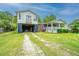 This charming raised house offers an open carport and a welcoming porch, ideal for relaxation and outdoor enjoyment at 312 Lake Moultrie Dr, Bonneau, SC 29431
