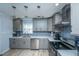 The kitchen is updated with gray cabinets, stainless steel appliances, and elegant backsplash at 312 Lake Moultrie Dr, Bonneau, SC 29431
