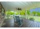 Cozy porch with rocking chairs, ceiling fan, and white railings, perfect for relaxation and enjoying the outdoors at 312 Lake Moultrie Dr, Bonneau, SC 29431
