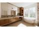 Bright bathroom with soaking tub, wood vanity, marble countertop, large mirrors, and modern fixtures at 33 Duany Rd, Mount Pleasant, SC 29464